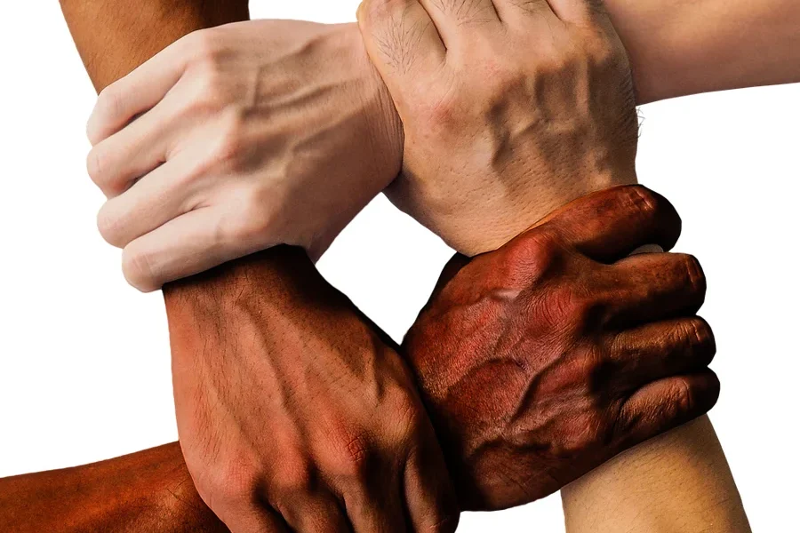 A group of people of different races and cultures locking hands for unity