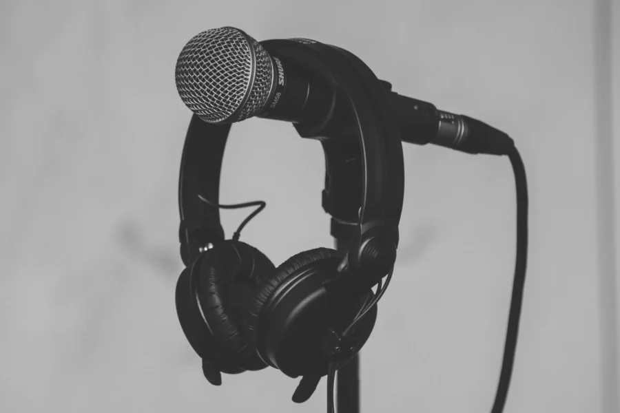 Black and white image of a set of headphones hanging off a microphone