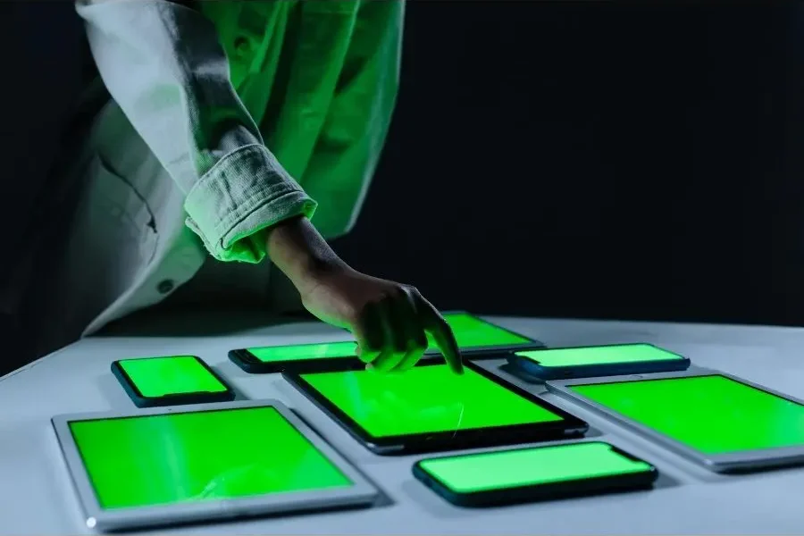 Person tapping one of multiple green glowing tablets looking at digital IDs