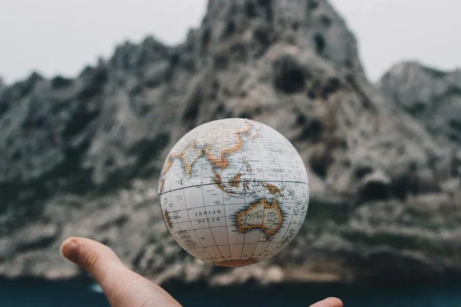 Outstretched hand throwing a globe into the water