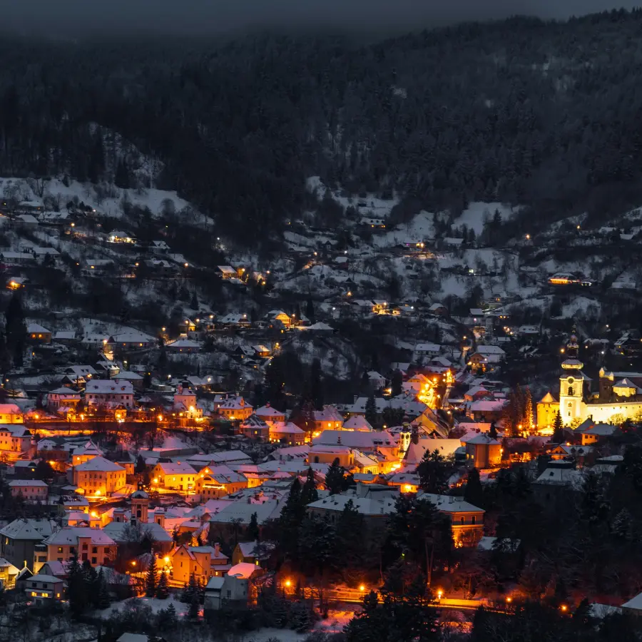 Warm lights shimmering across a snow-covered mountain village during the Winter Solstice
