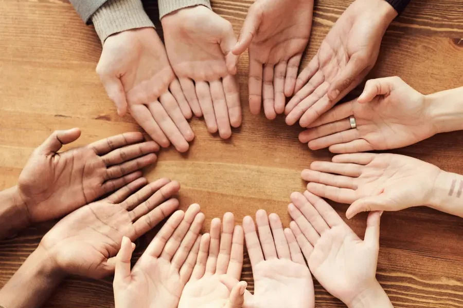 Hands from different cultures forming a shared circle